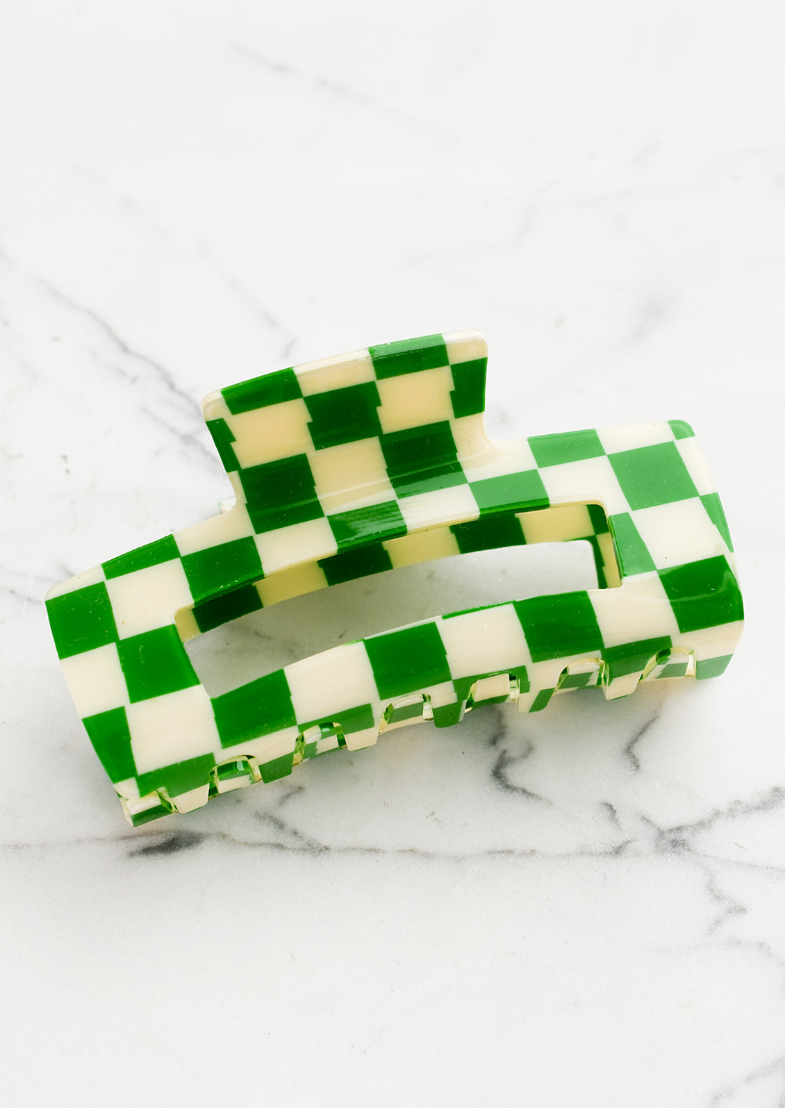 A checker print hair claw in green and ivory.