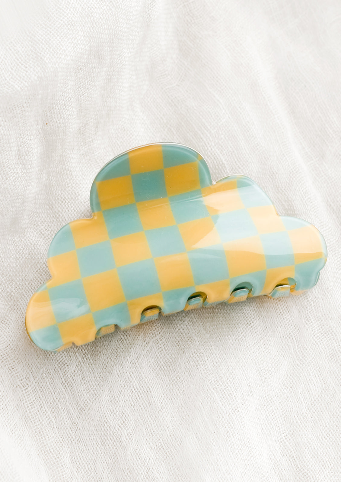 A cloud shaped hair claw in yellow and aqua checker.