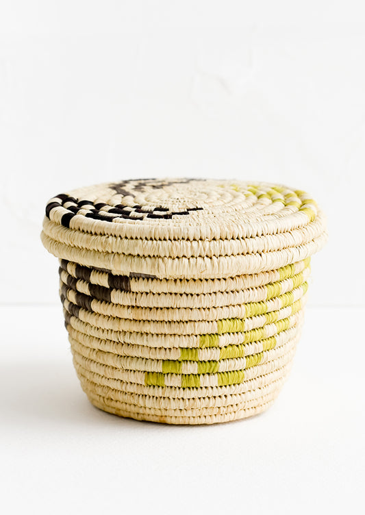 A small raffia lidded basket with woven checkered pattern.