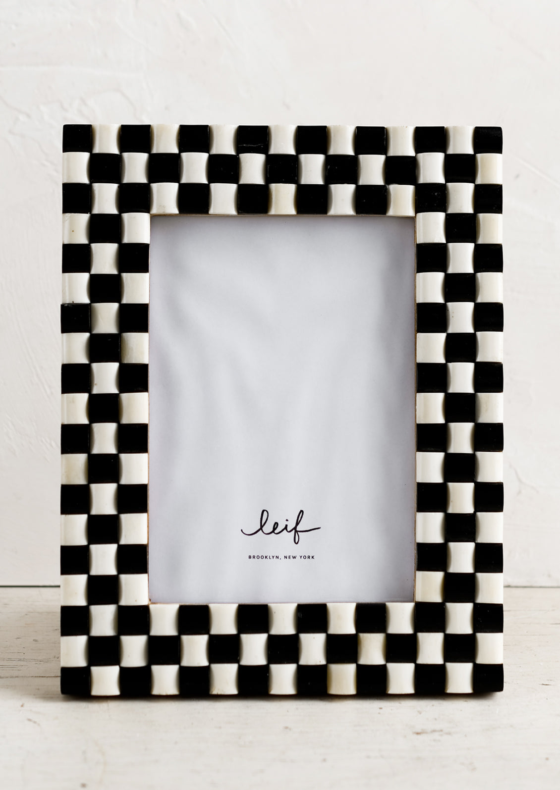 A checkered weave picture frame in black and ivory.