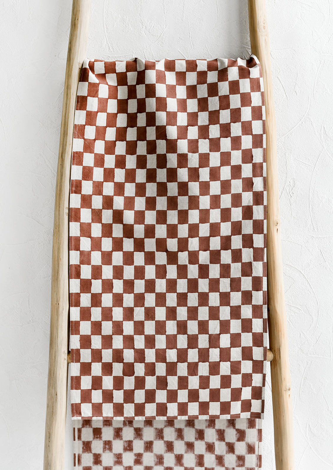 A linen table runner in clay checker print.