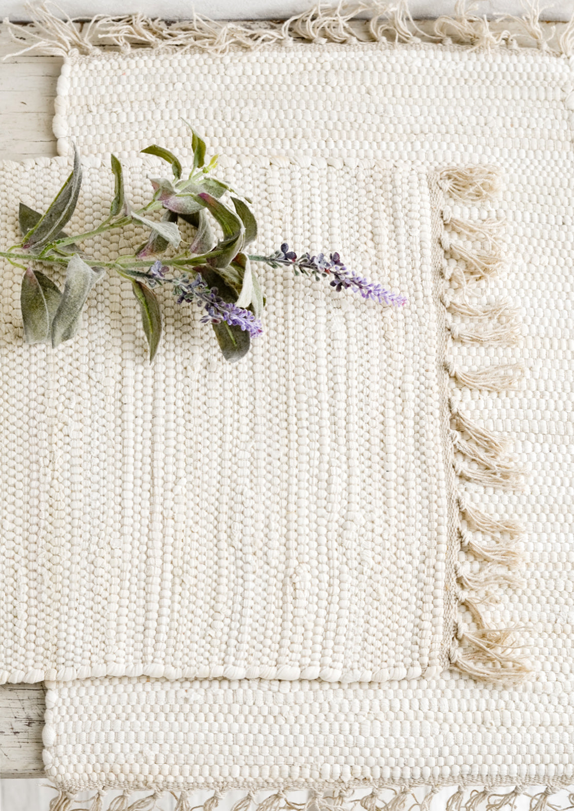 Two chindi weave placemats in ivory with tonal fringed trim.