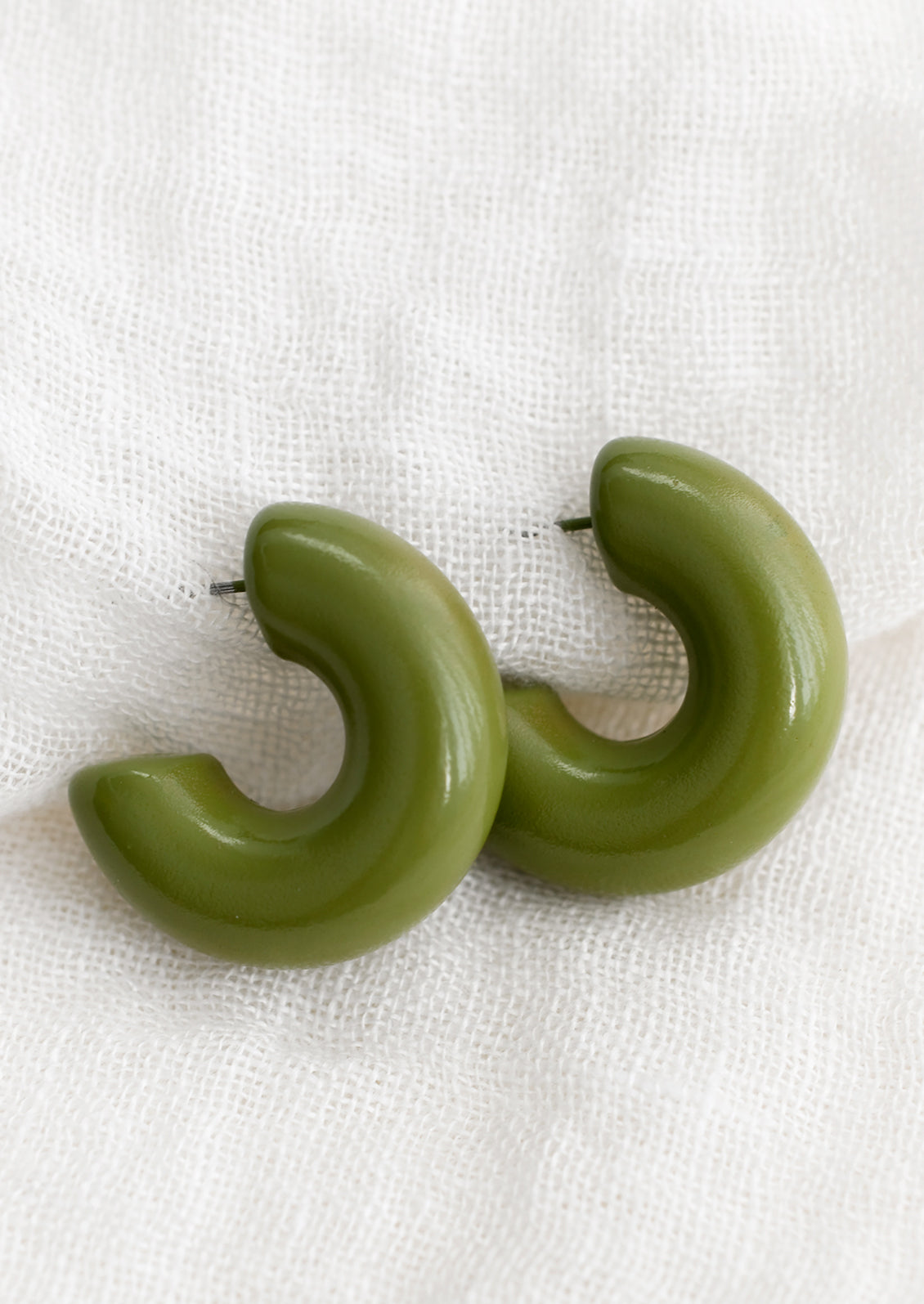 A pair of chunky gloss finish hoop earrings in martini olive.