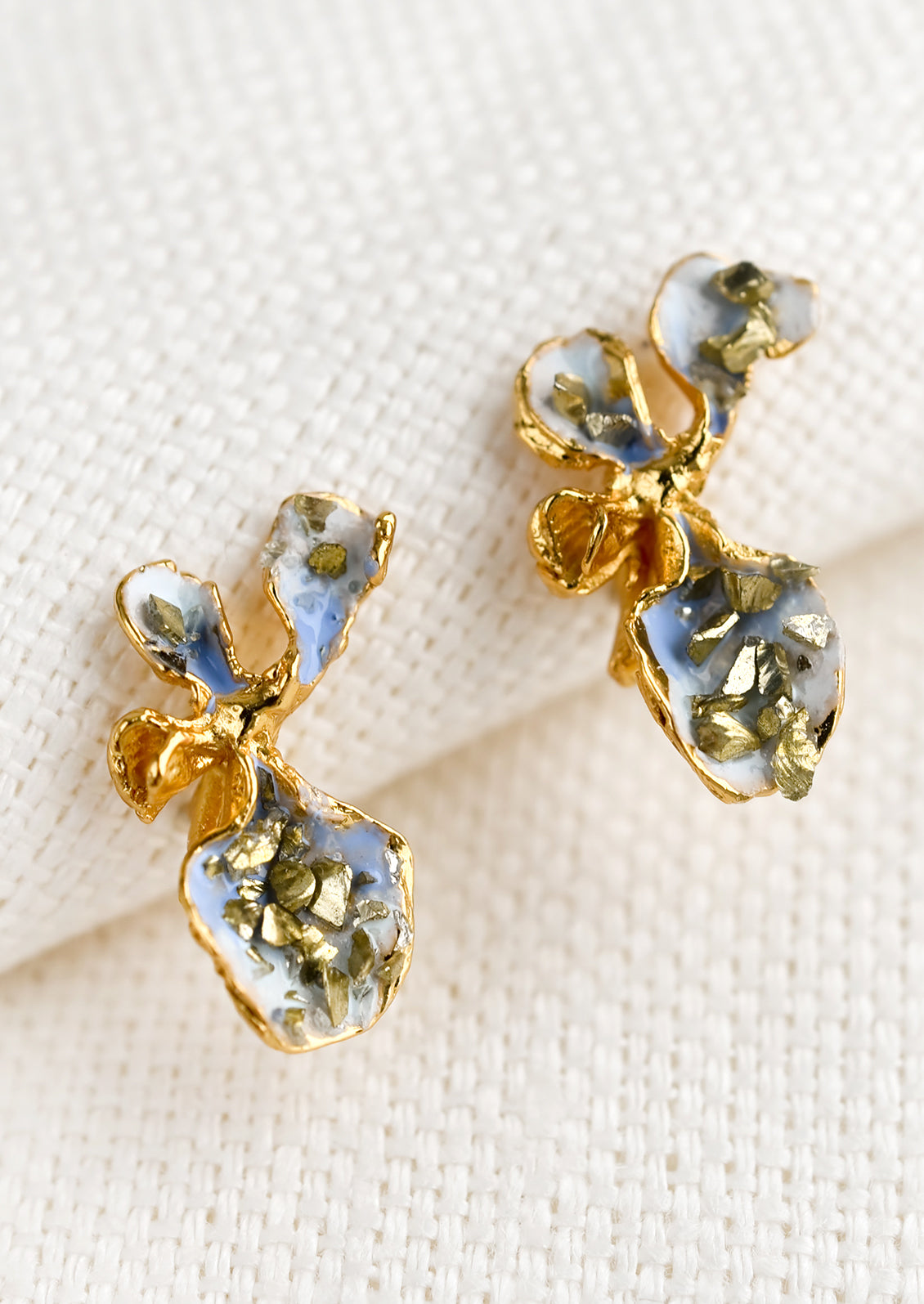 A pair of enamel painted gold earrings in shape of flower.