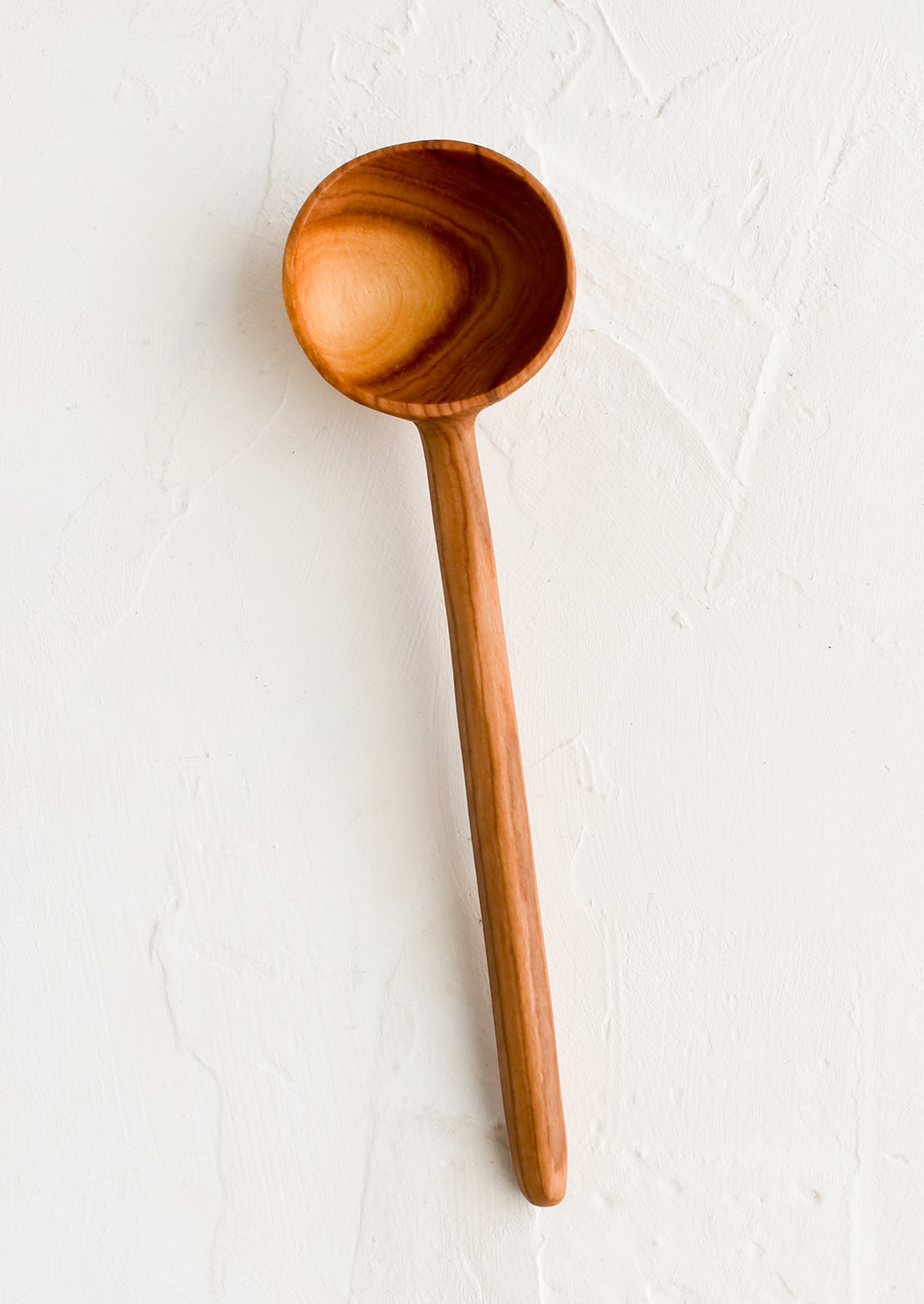 A plain olivewood coffee scoop without any detailing.