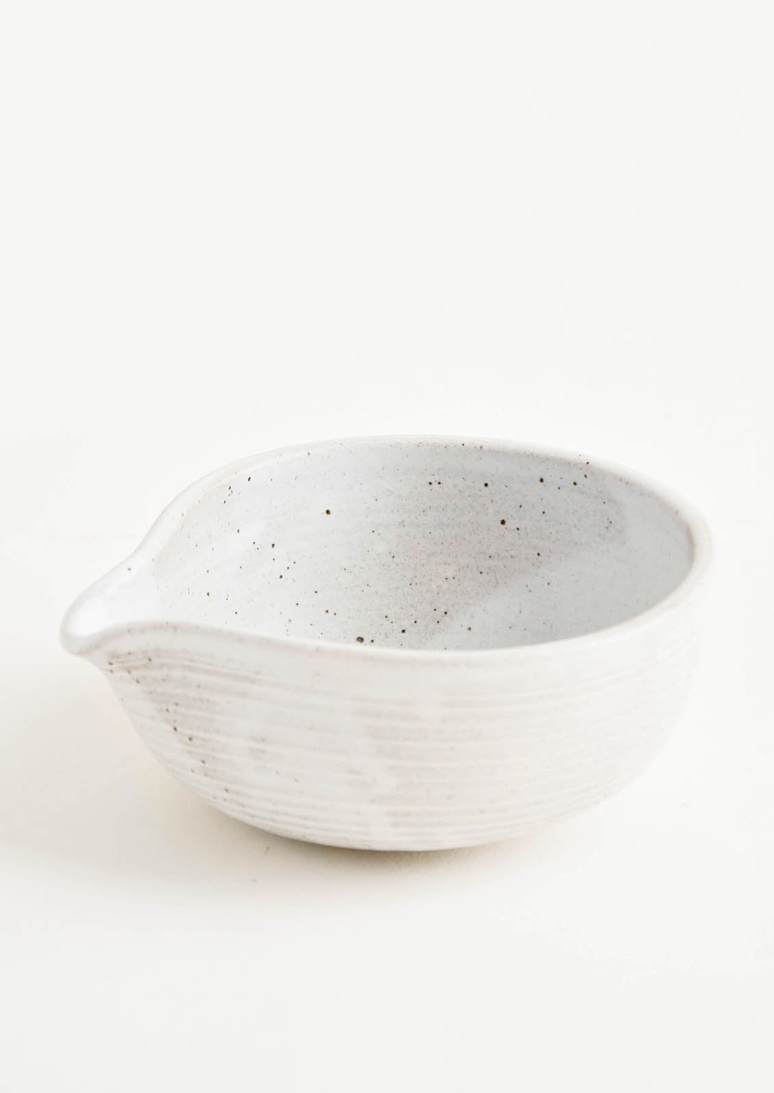 A gray-white spouted ceramic bowl.