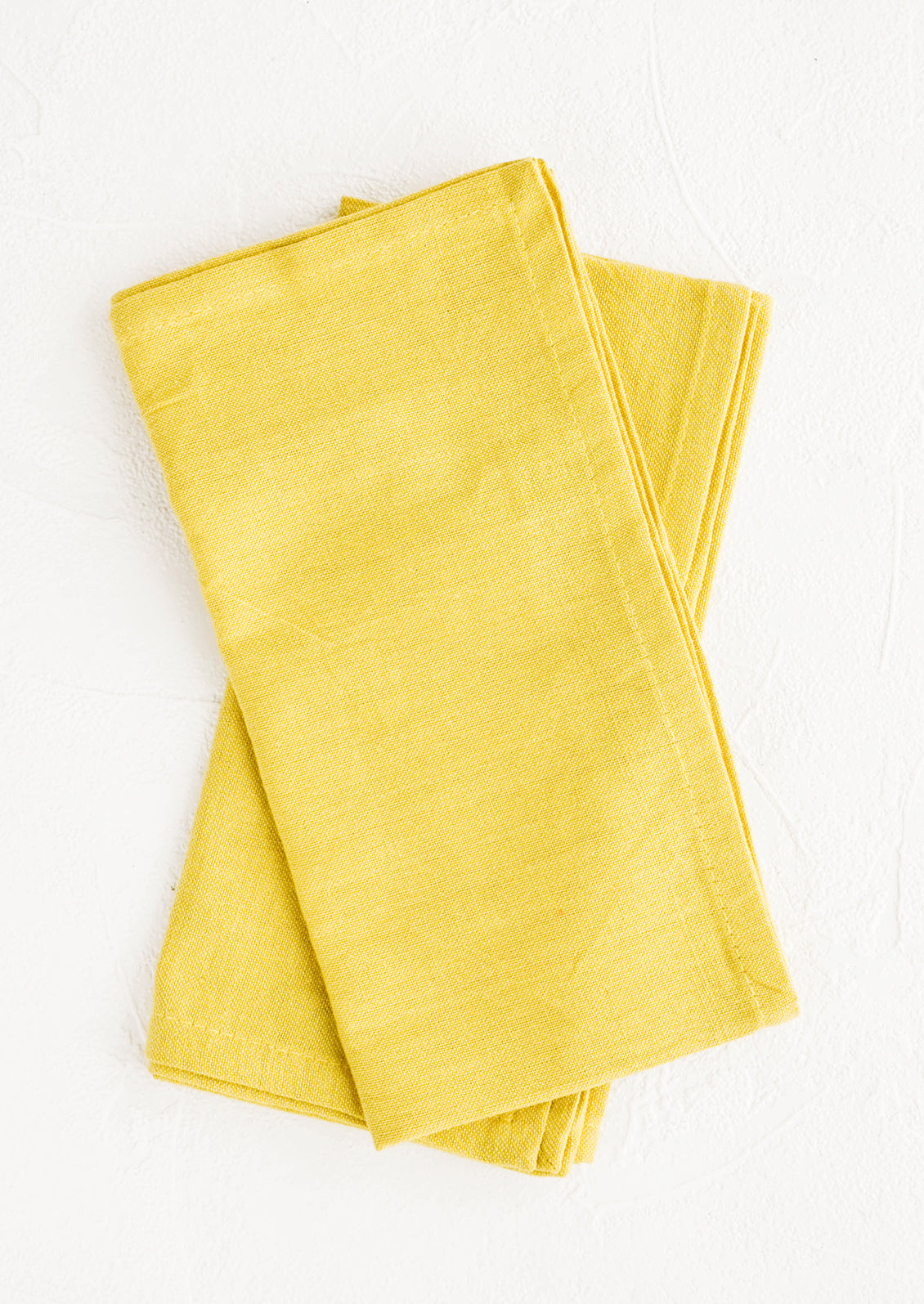 Pair of folded cotton napkins in chartreuse hue
