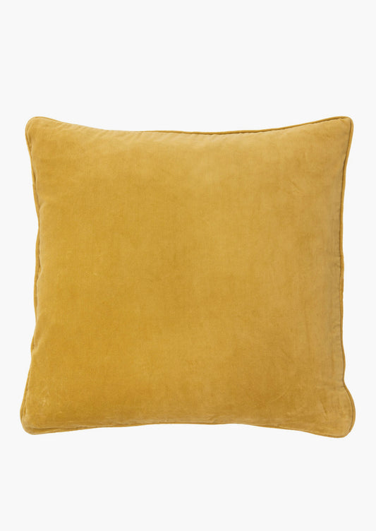 A square velvet throw pillow in dijon yellow.