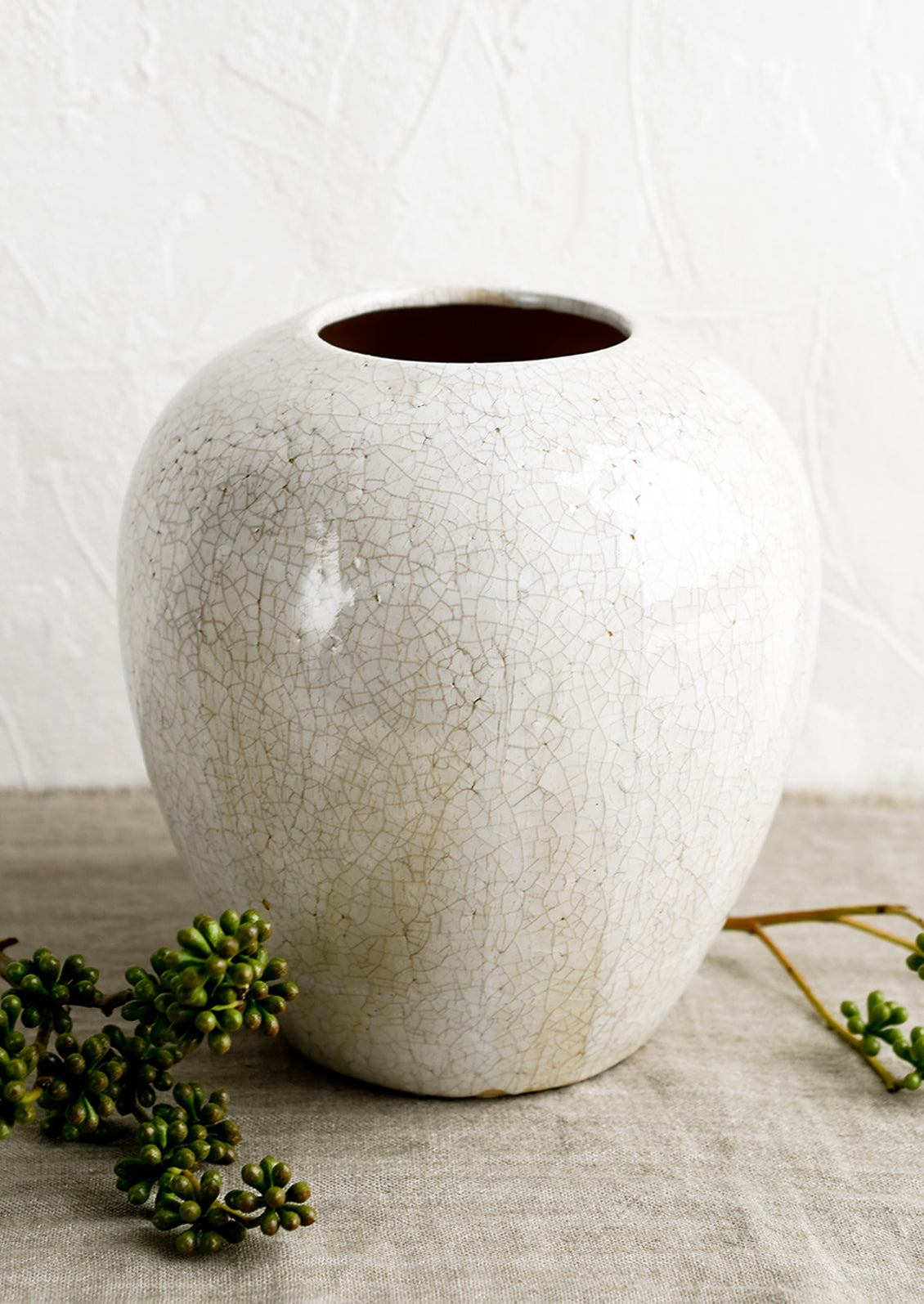 An off-white large ceramic vase with crackle pattern.