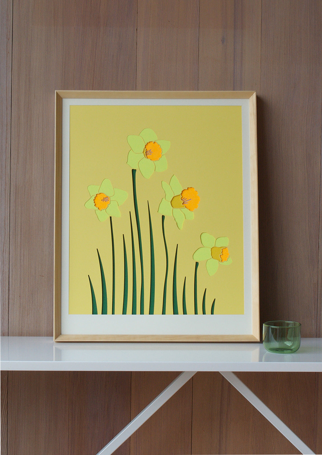 A lasercut artwork depicting daffodils on yellow background.