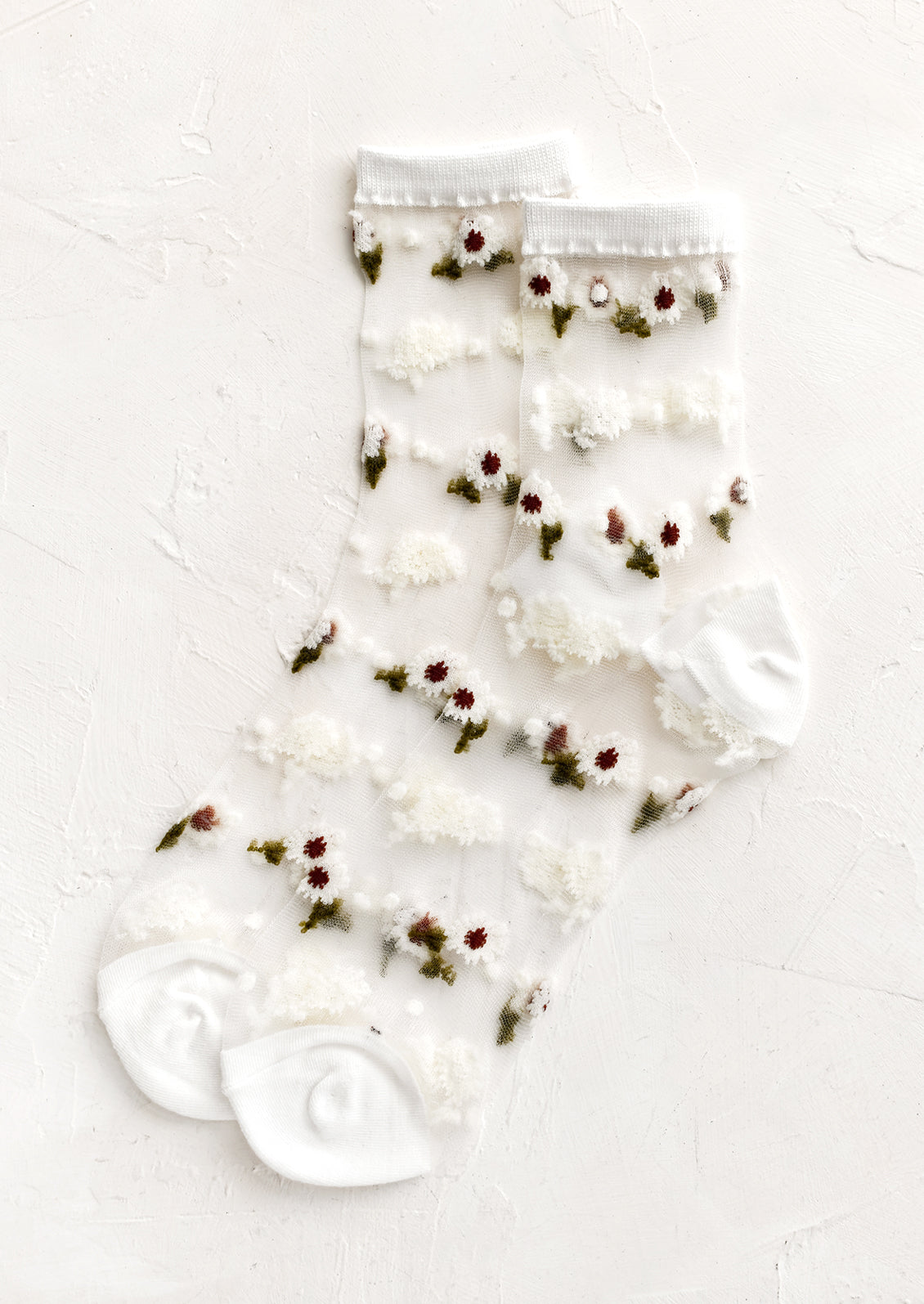 Sheer ankle socks with floral print and white trim.