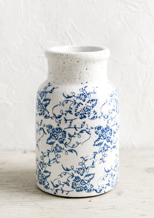 A blue and white ceramic vase with antique floral print.