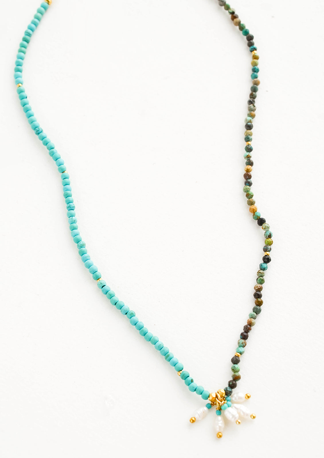 Beaded necklace with round turquoise stone beads, five freshwater pearls dangle at front and center