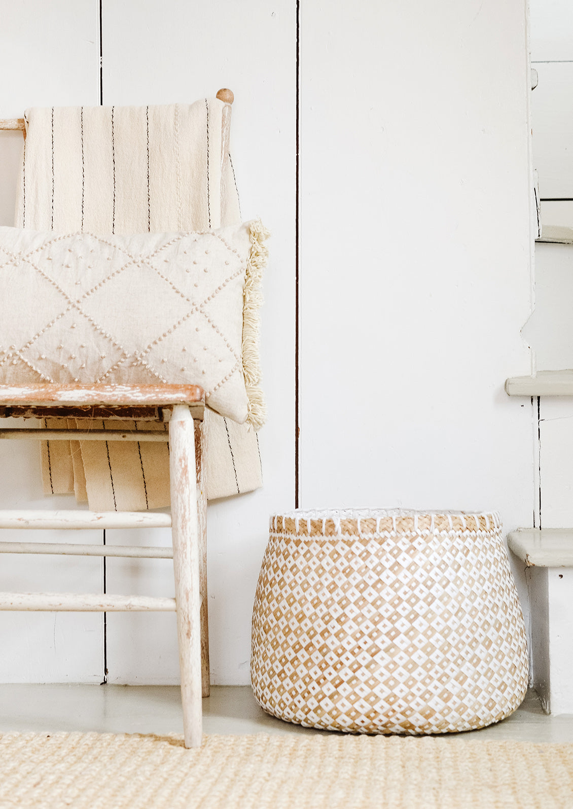 An interior setting with chair, pillow and basket.