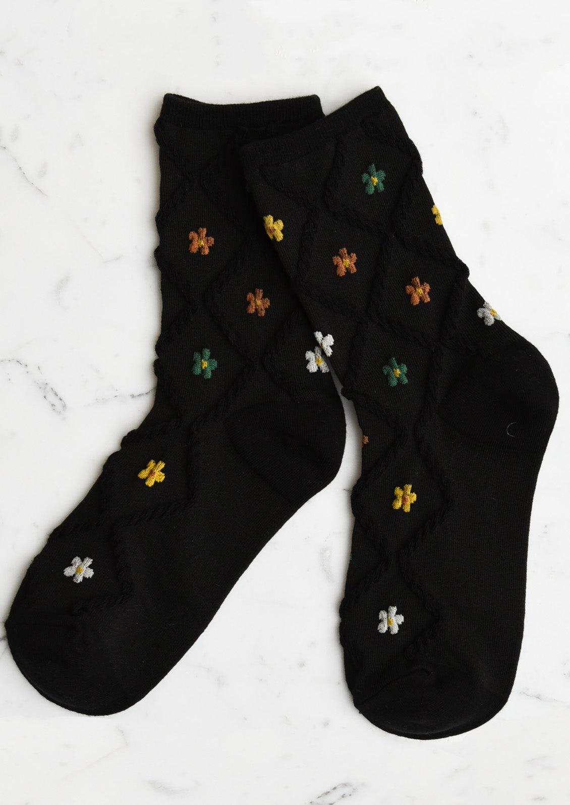 A pair of black socks with diamond pattern and florals.