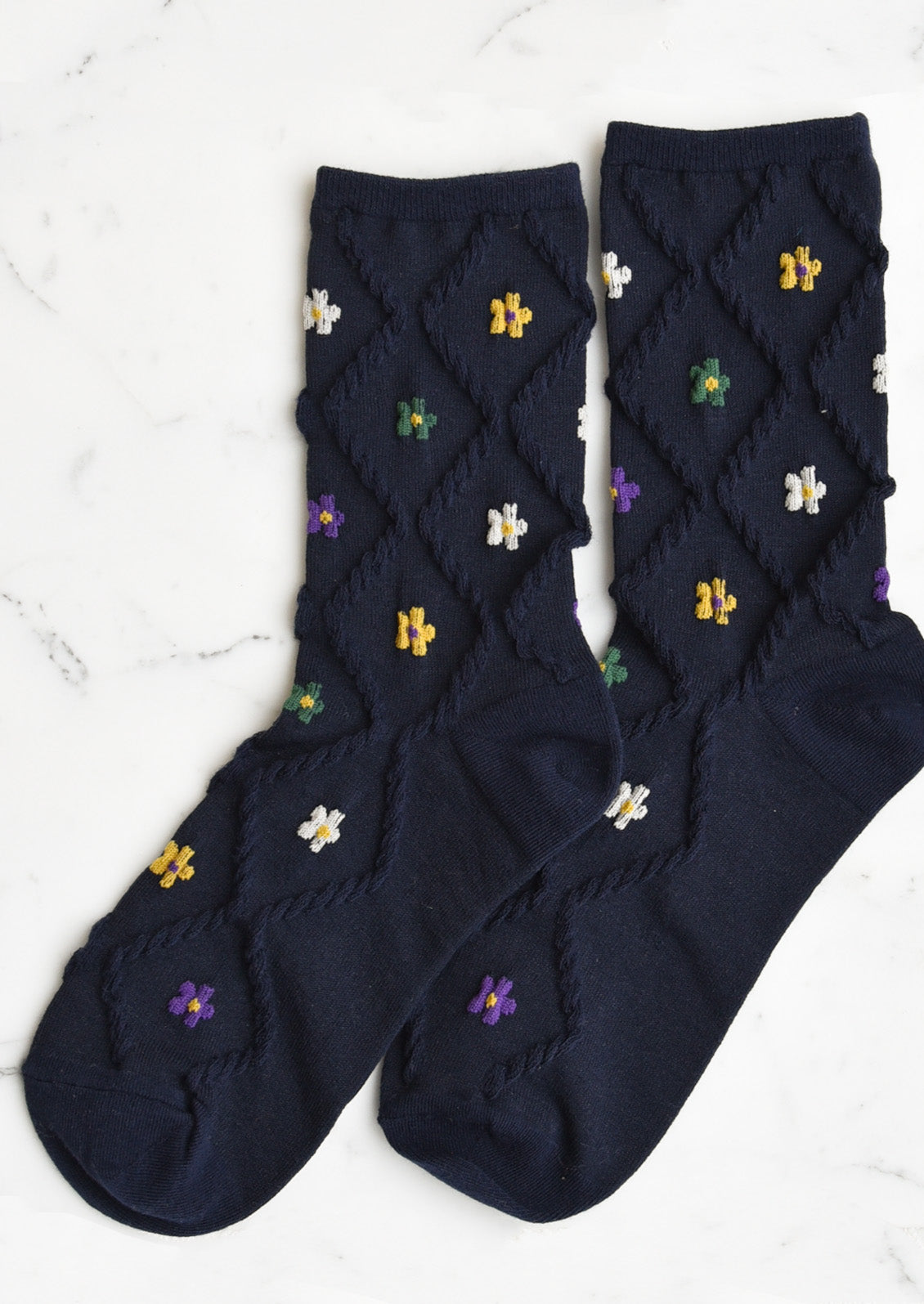 A pair of navy socks with diamond pattern and florals.