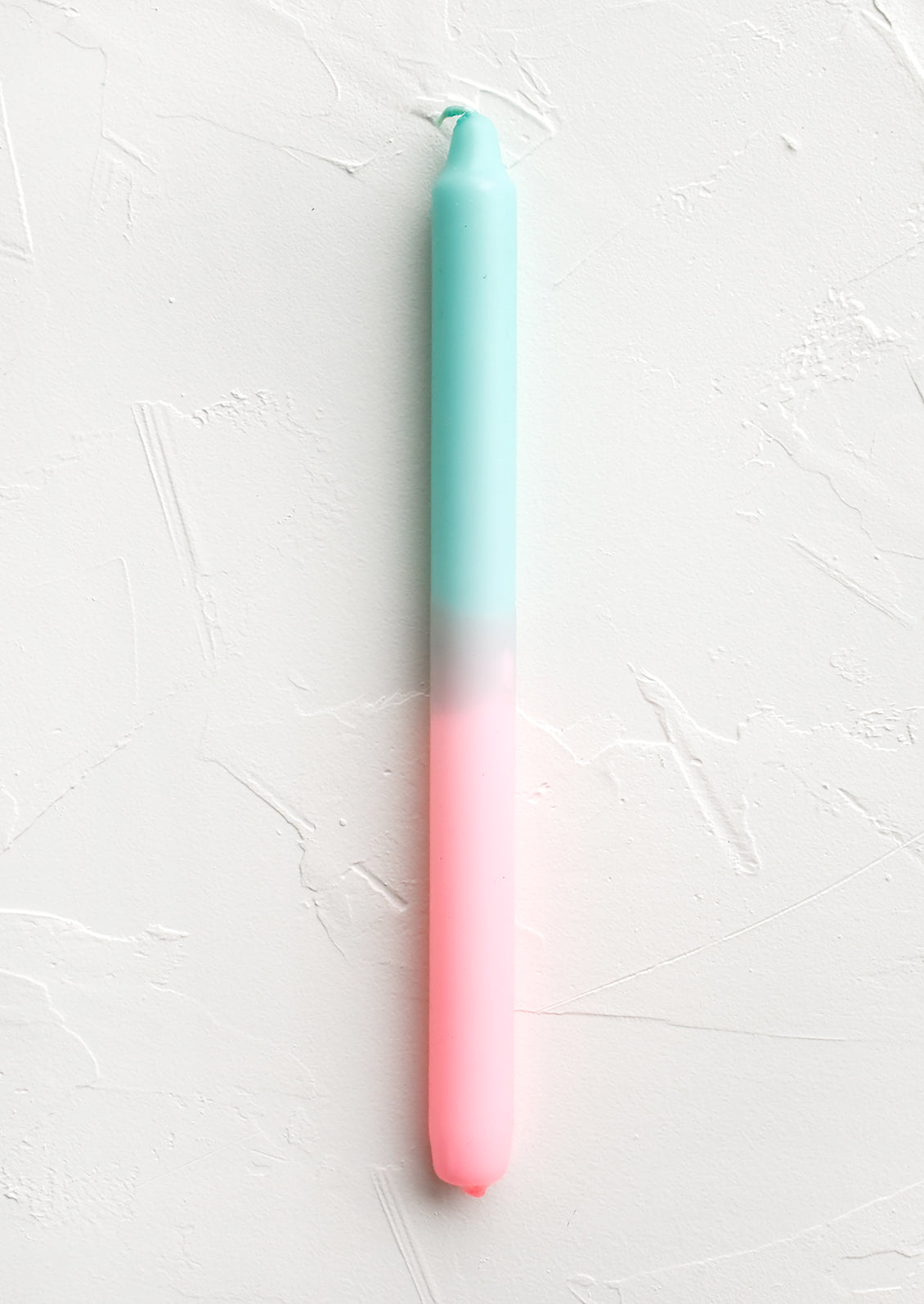 A straight taper candle in mint and pink.