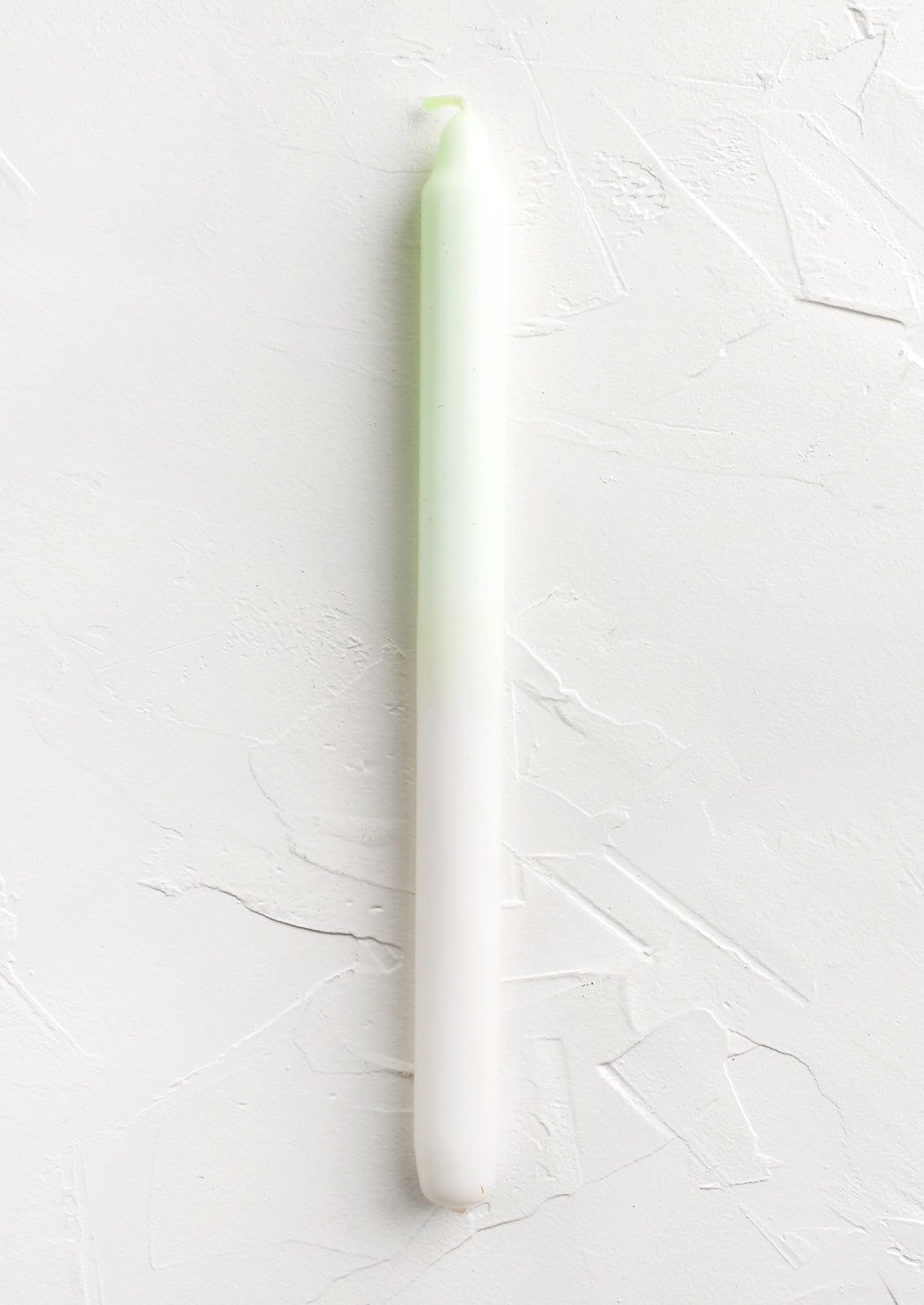 A straight taper candle in lime and white.