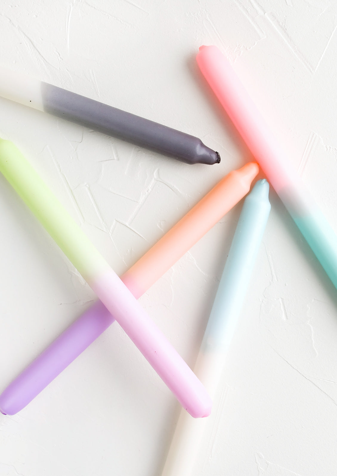 Dip dyed taper candles in an assortment of colors.