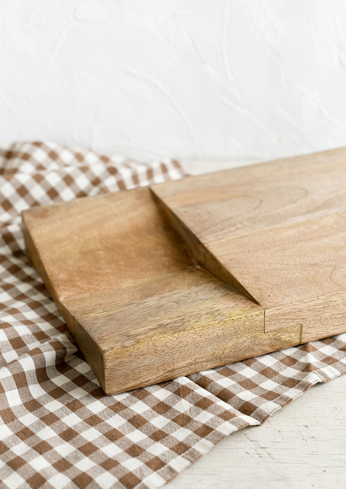 A thick mango wood chopping board with divoted section at 1/3.