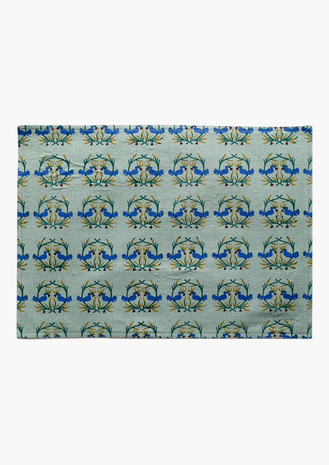 A placemat with block print of kissing birds.