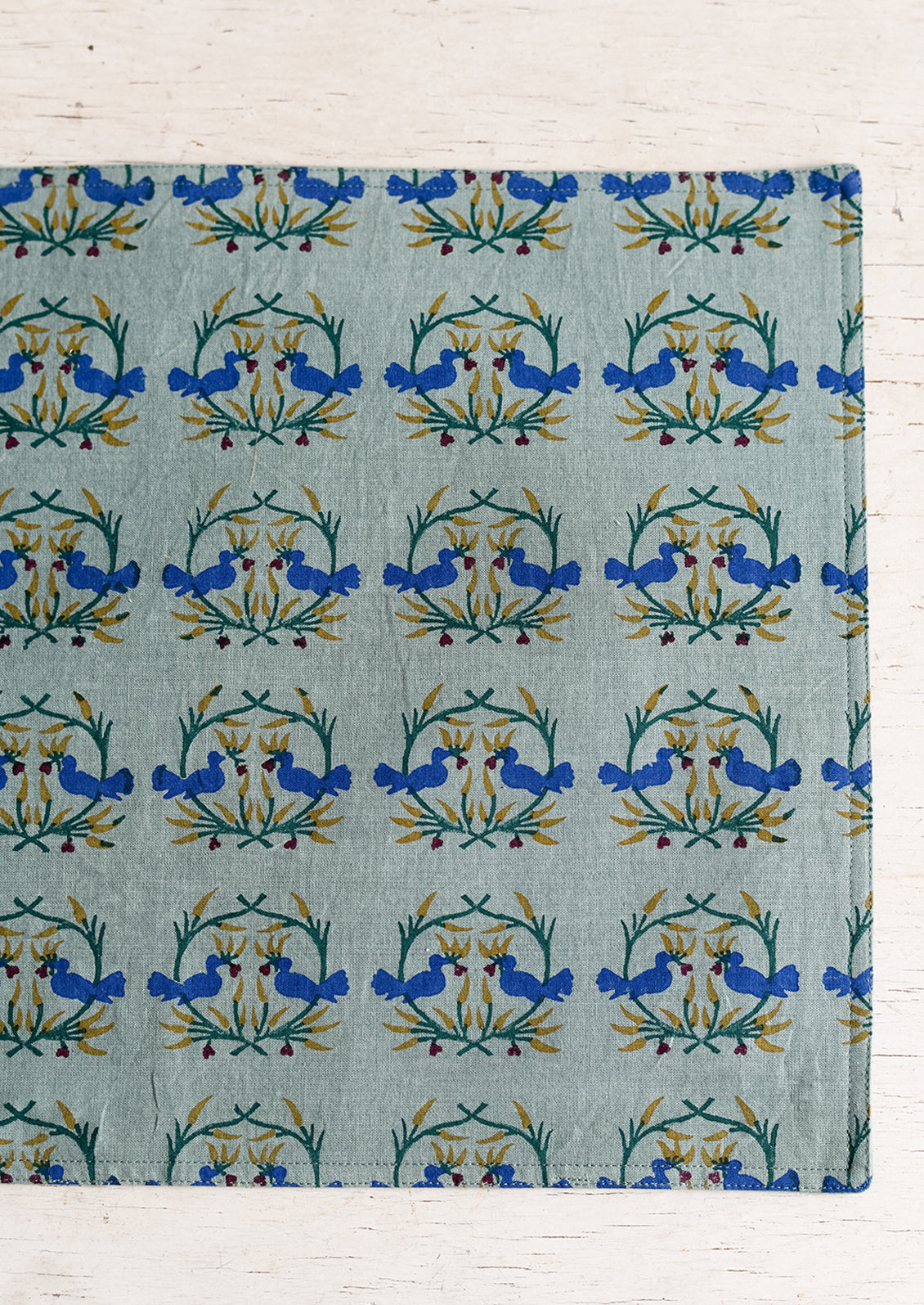 A placemat with block print of kissing birds.