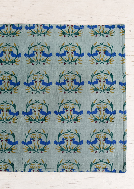 A placemat with block print of kissing birds.