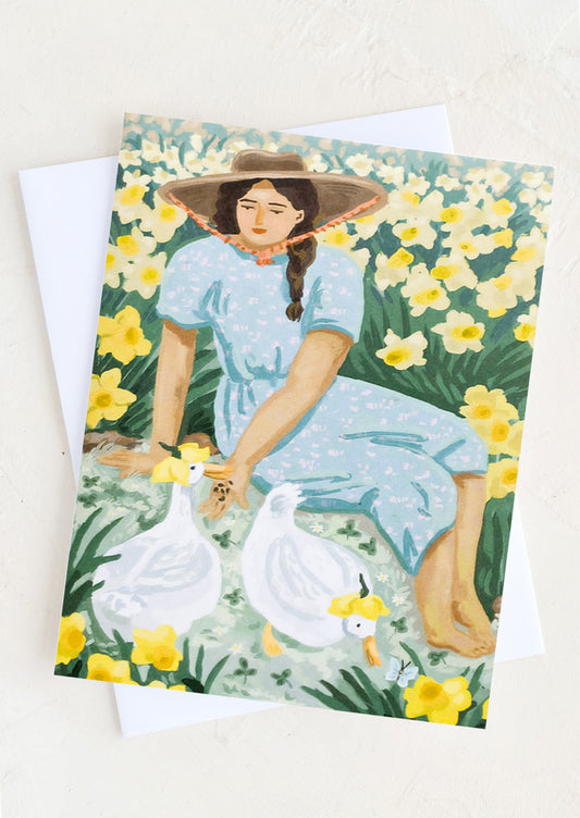 A card with illustration of a woman in a field with daffodils and ducks.
