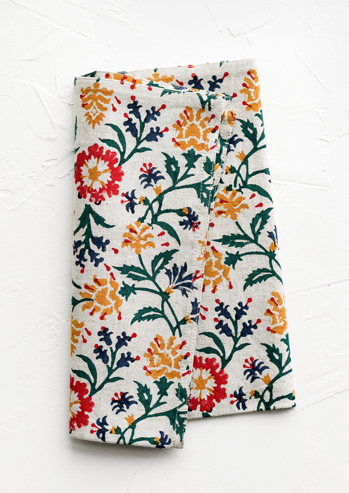 A linen napkin with primary color floral print.