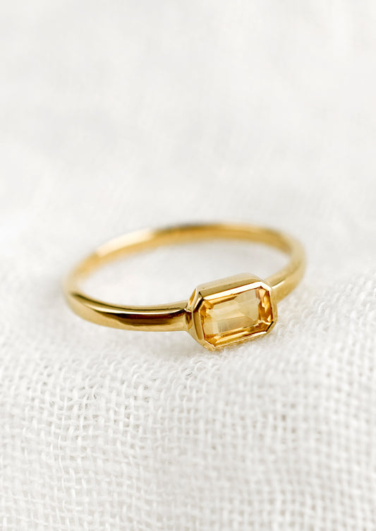 An emerald cut gold ring with citrine stone.