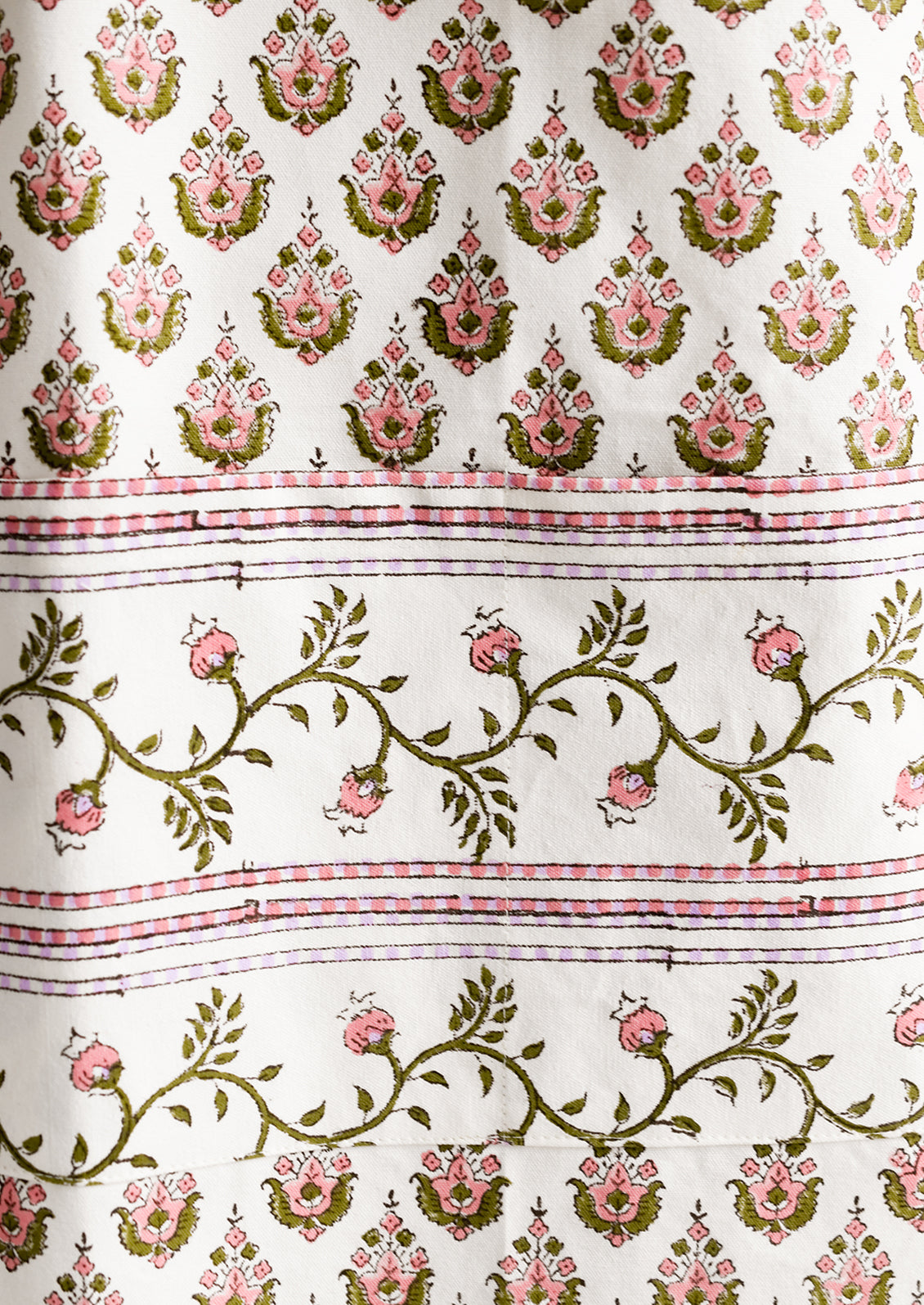 A printed apron in pink, green and lavender floral block print.
