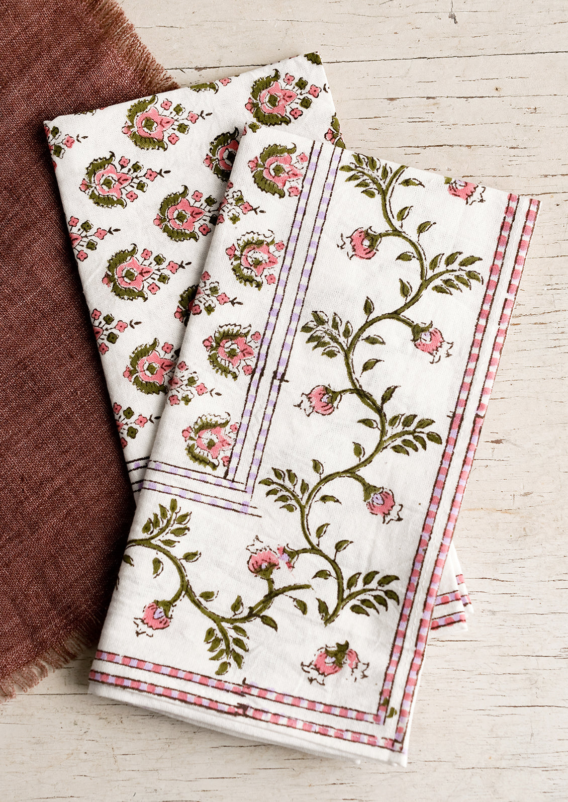 A pair of block print napkins in pink and purple floral.
