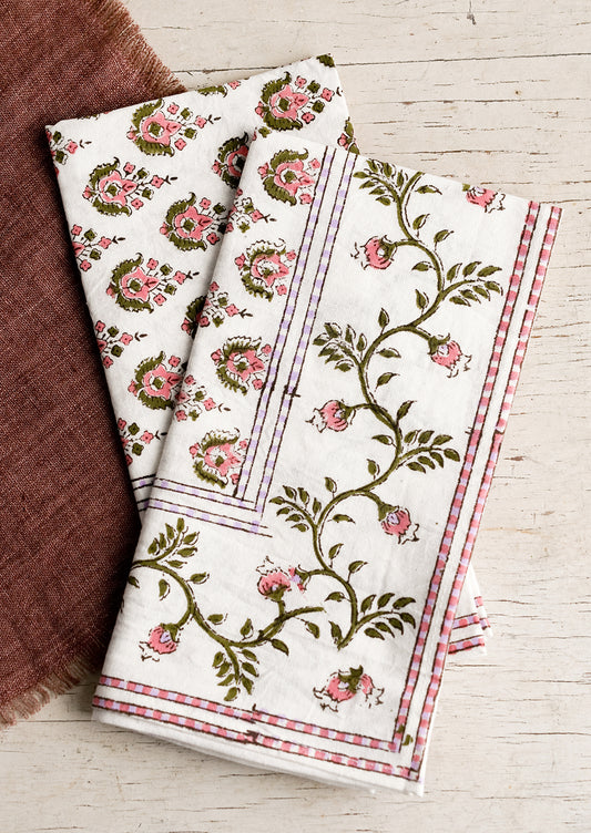 A pair of block print napkins in pink and purple floral.