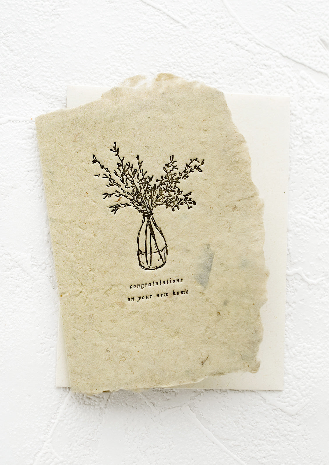 A greeting card made from handmade paper in green with letterpress image and text.