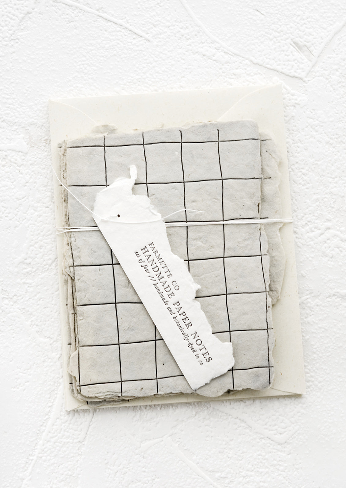 Packaged set of cards made from handmade paper with a letterpress printed grid pattern.