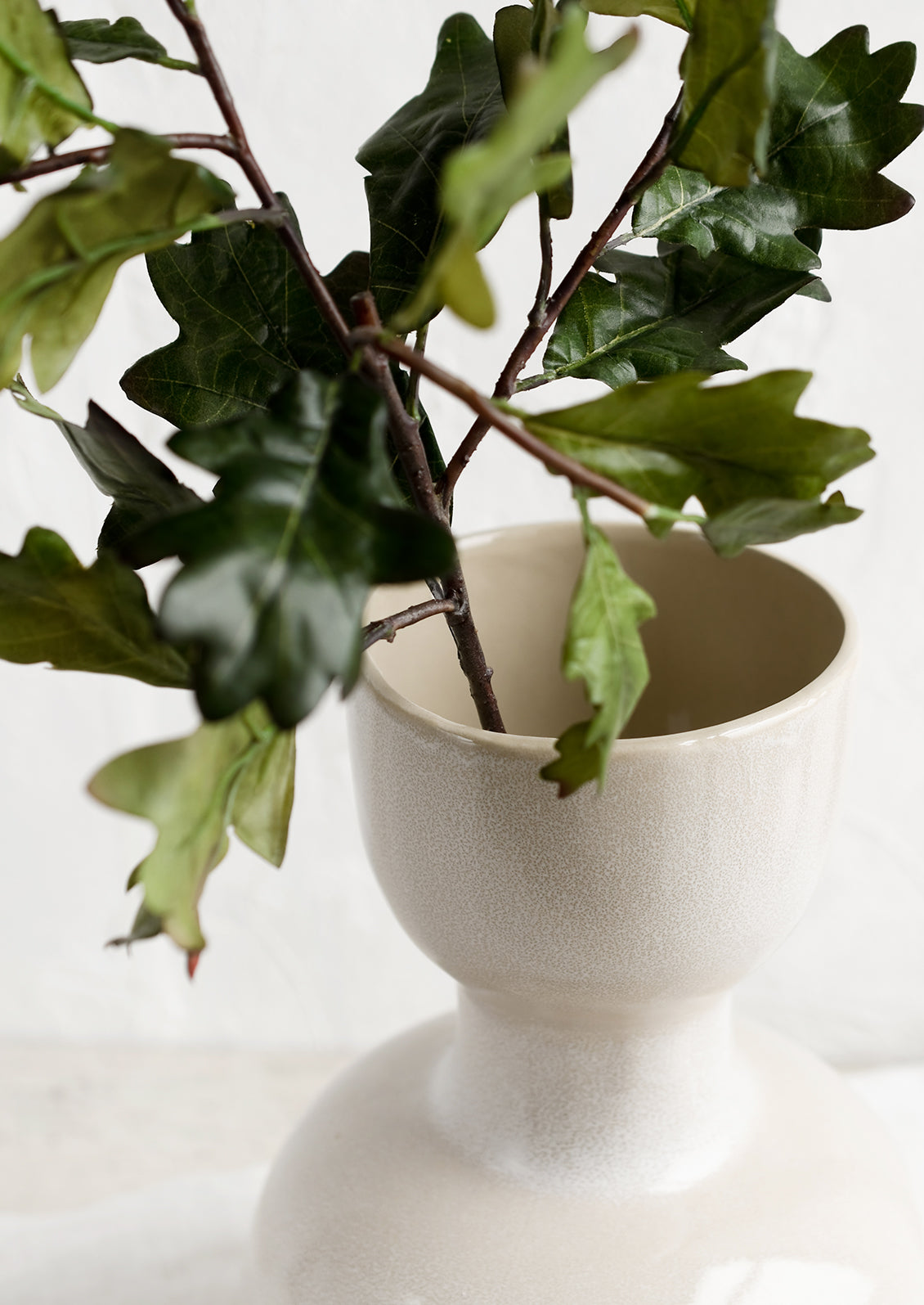 A faux oak leaf stem in a vase.