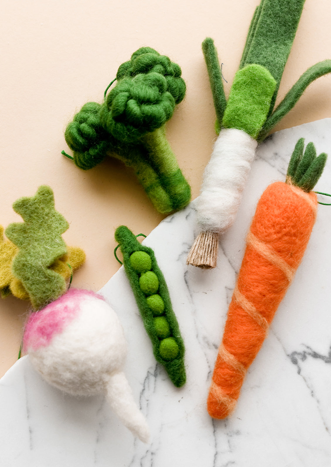 Felted holiday ornaments of assorted vegetables.