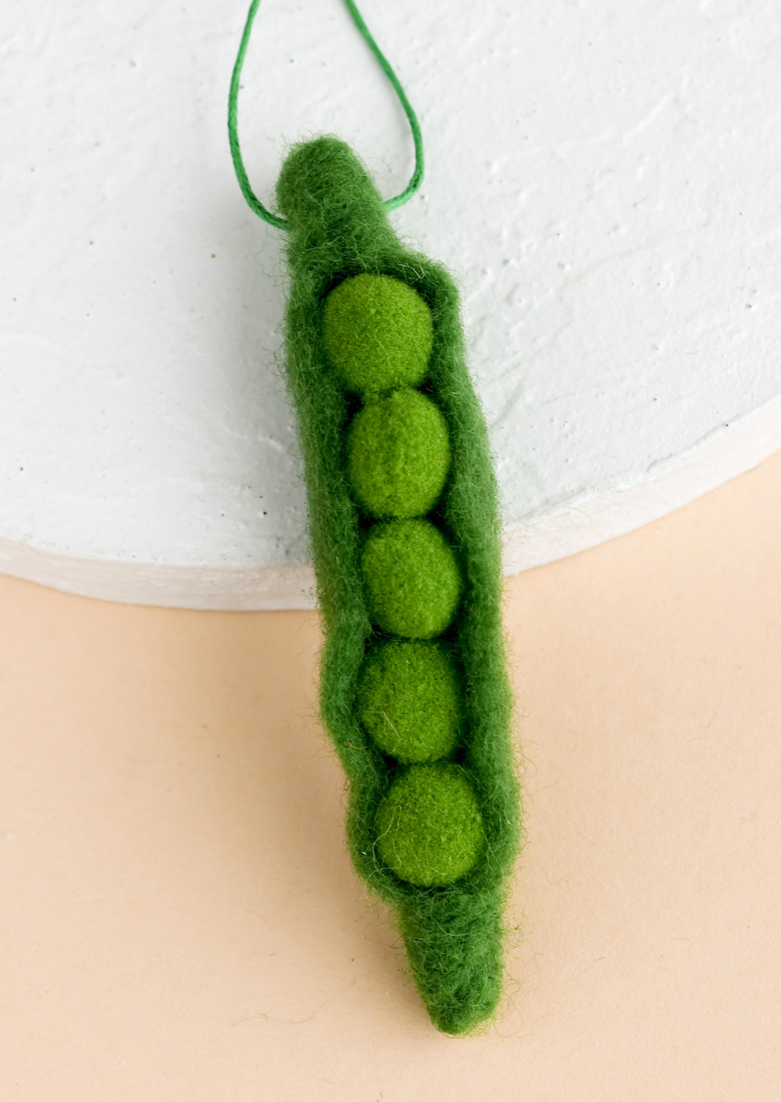 A felted ornament of a pea.