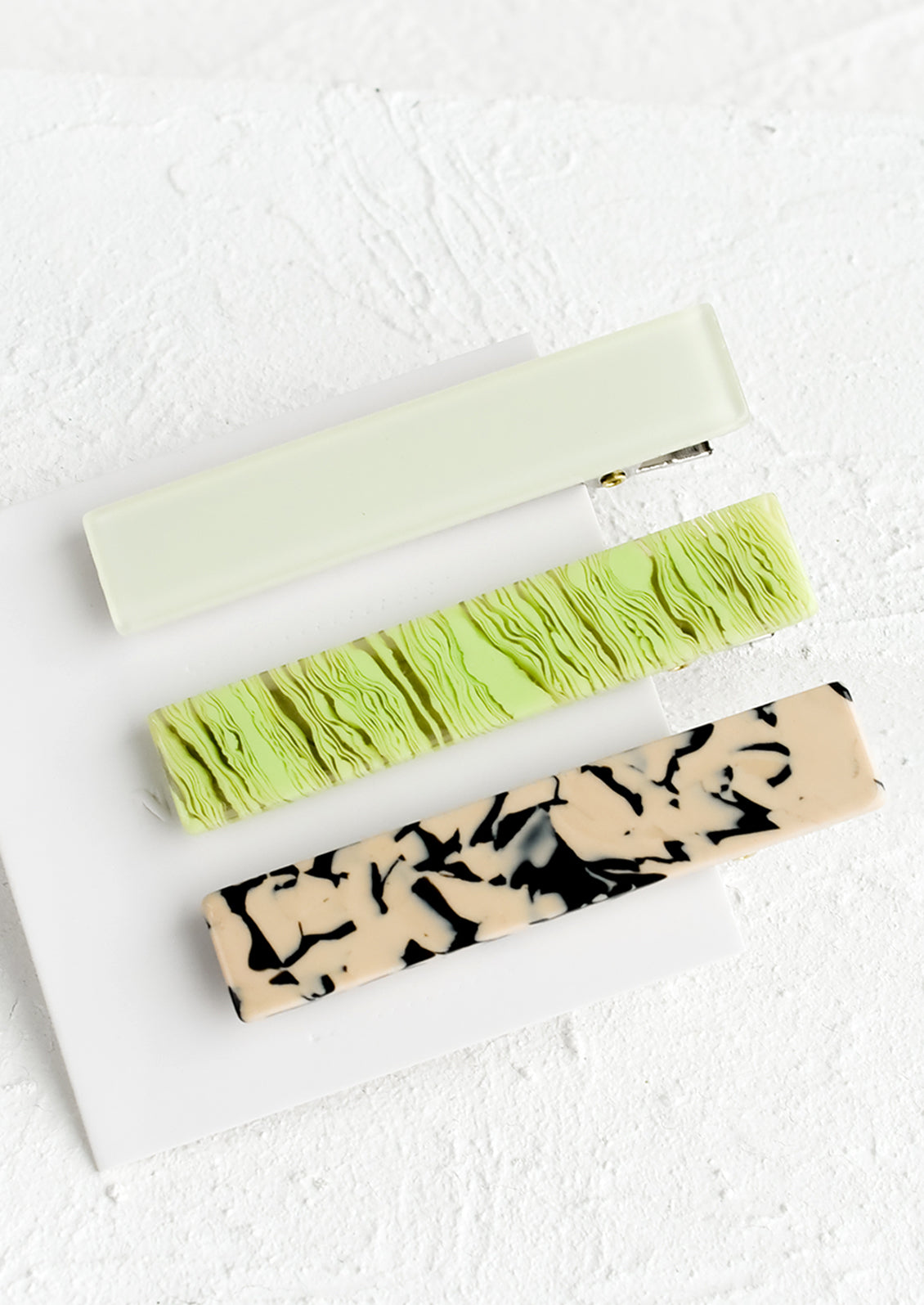A set of three rectangular acetate hair clips in neon green mix.