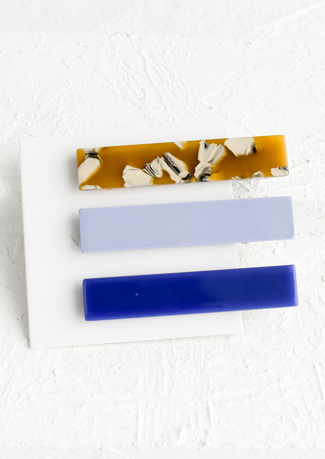 A set of three rectangular acetate hair clips in periwinkle and brown mix.
