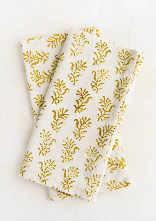 A pair of block printed napkins in white with yellow floral print.