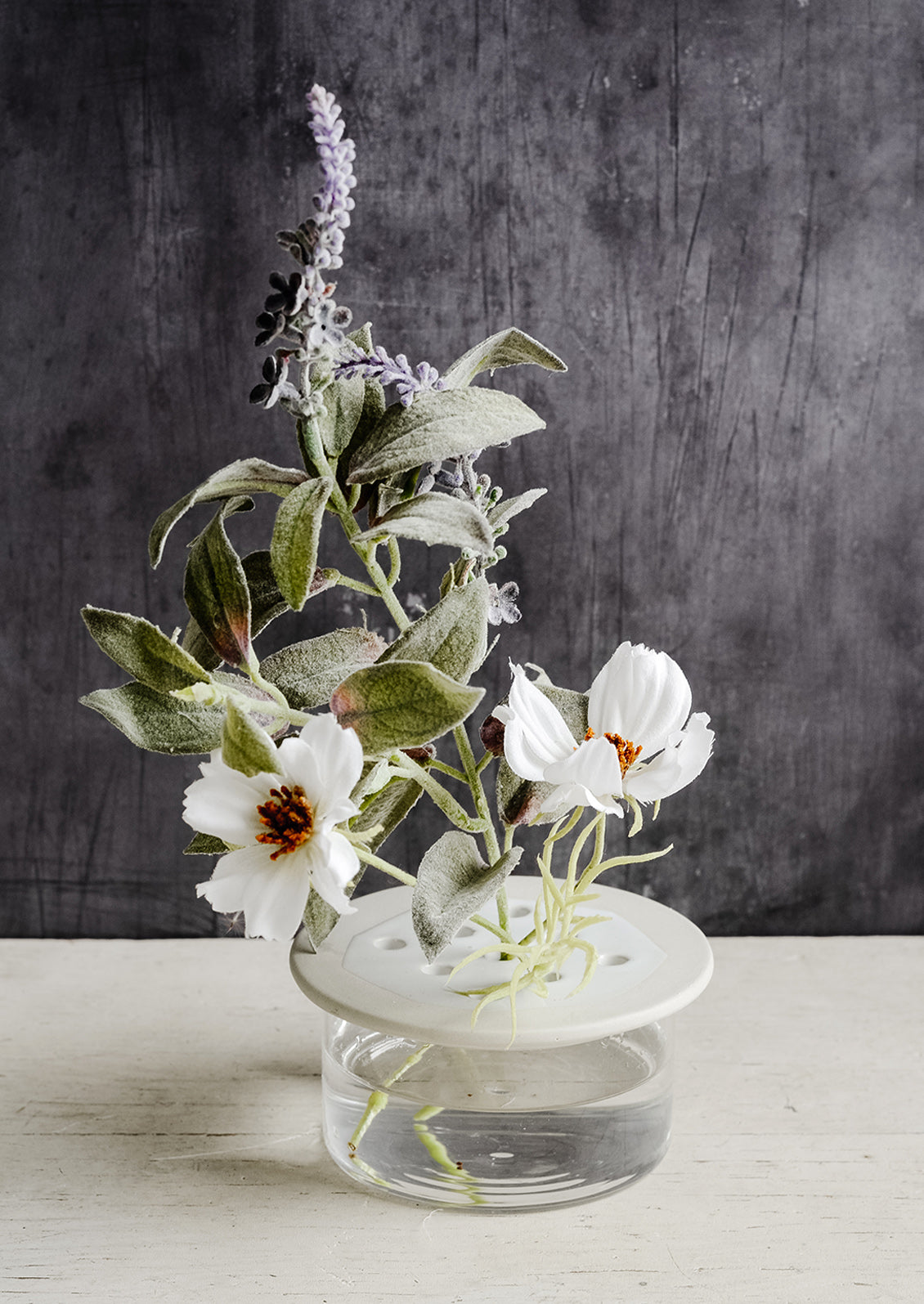 A short ceramic and glass flower frog with lavender and cosmos.