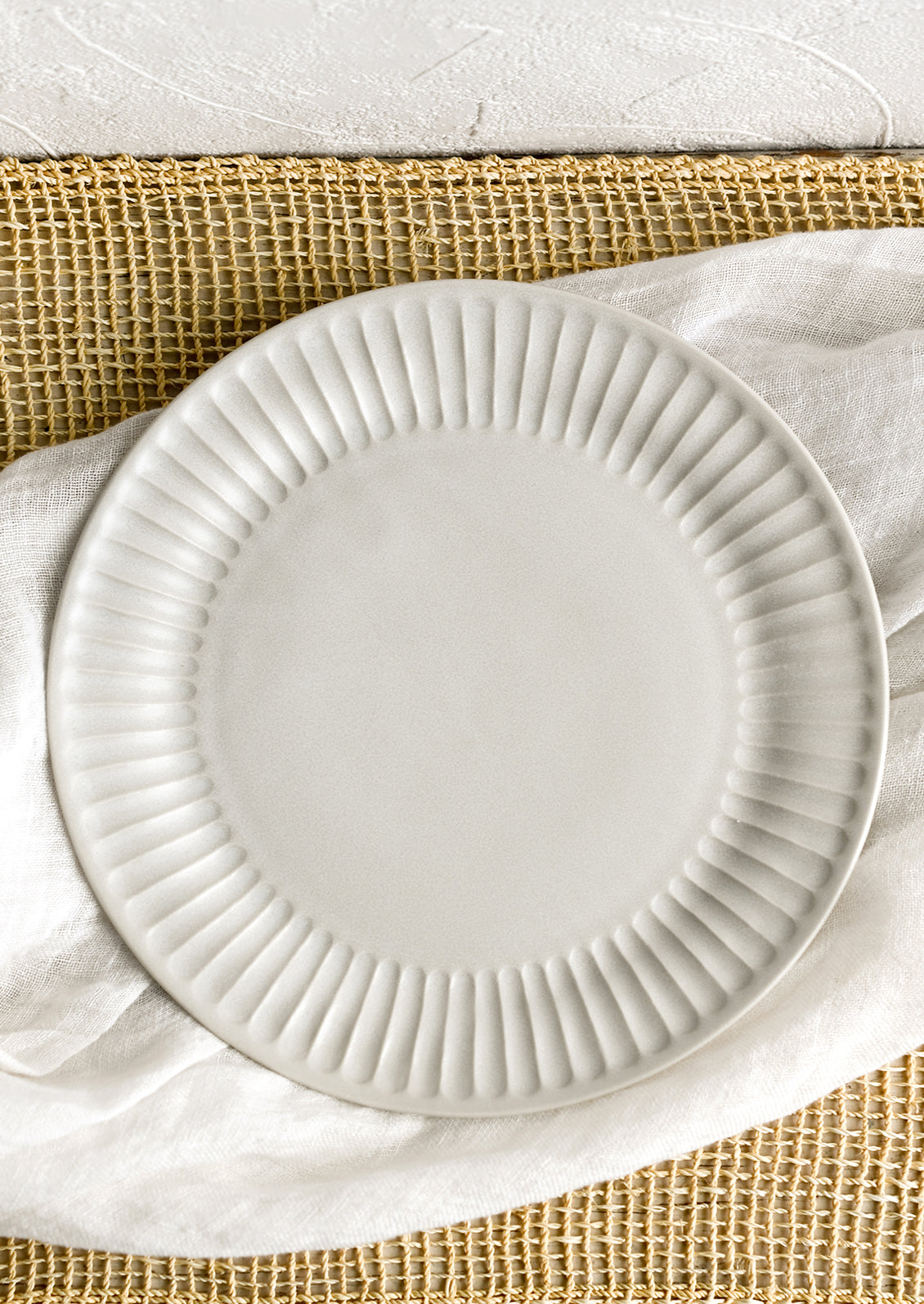 A white porcelain plate with fluted texture around rim.
