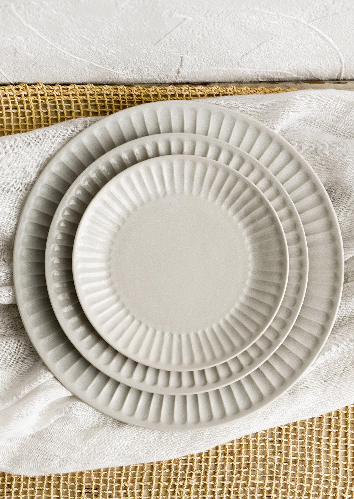 White fluted plates in three incremental sizes.