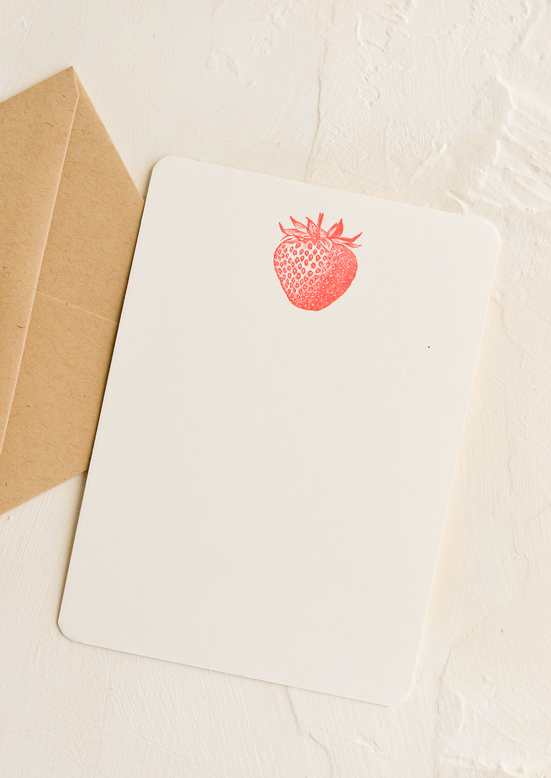 A white notecard with strawberry letterpress printed at top, with kraft envelope.