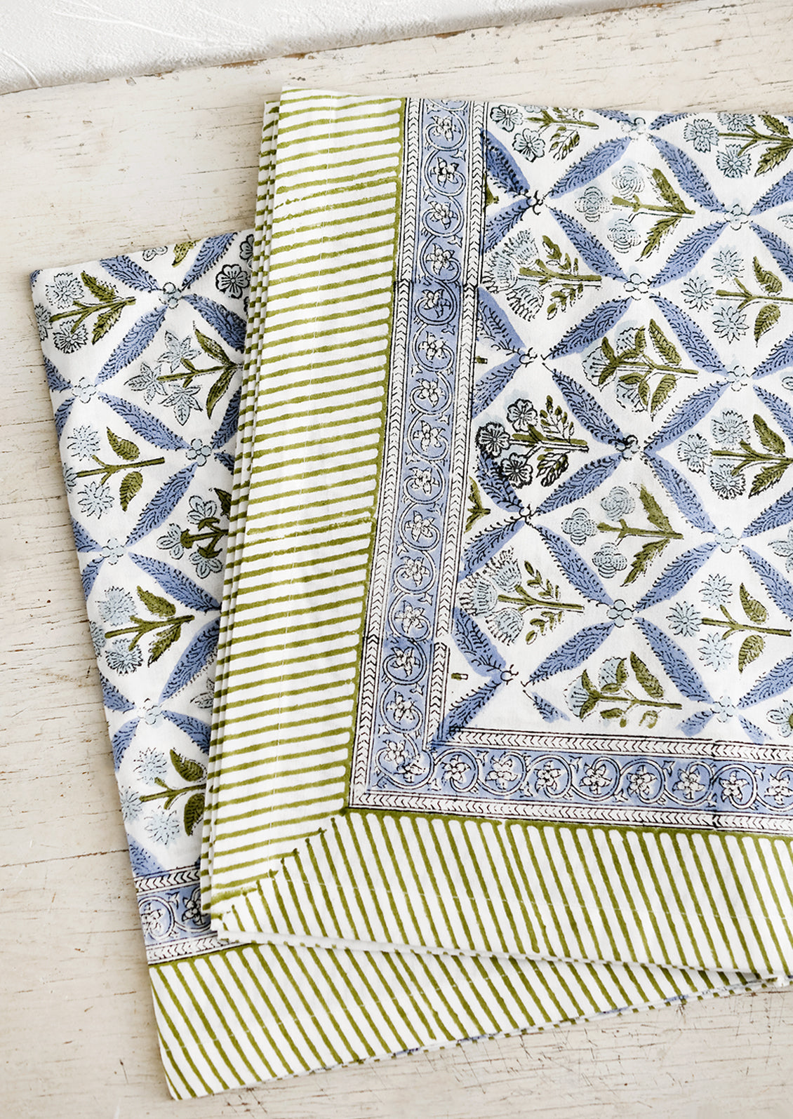 A block printed floral tablecloth in blue and green.
