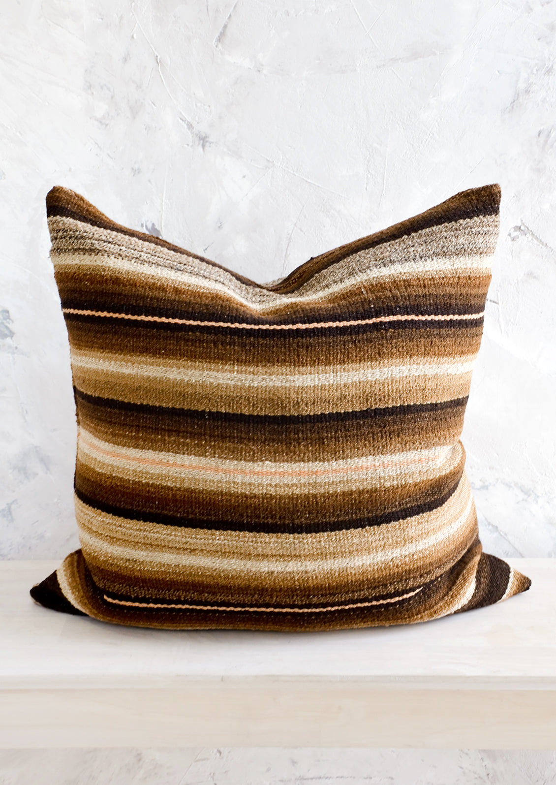 Throw pillow made from vintage wool fabric in brown, cream and peach stripes
