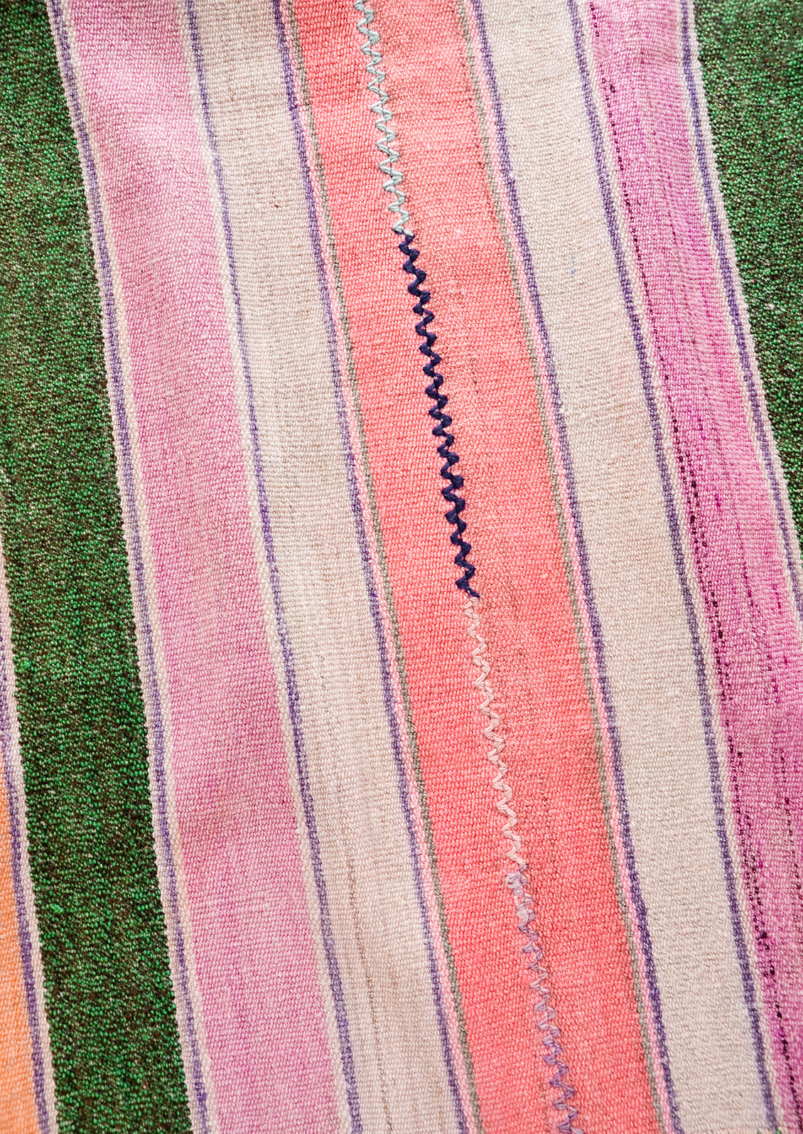 Wool textile in multicolor striped pattern with zigzag stitch detail at center