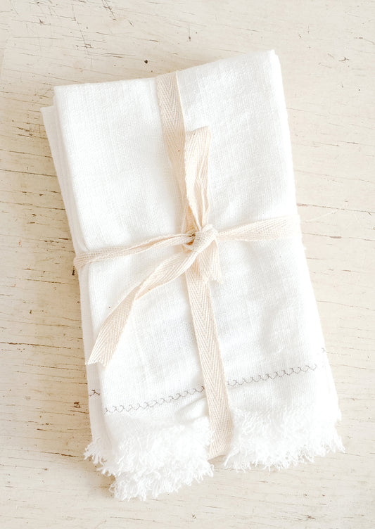 White cotton dinner napkins folded and bound with twine