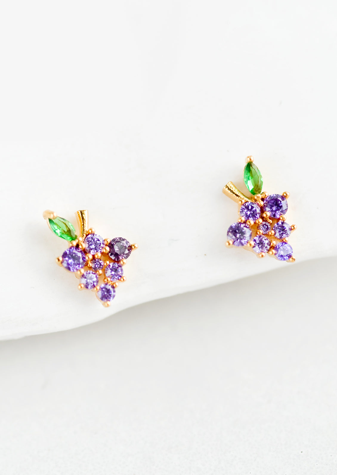 A pair of small crystal stud earrings in the shape of a bundle of grapes.